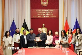 Ông Đỗ Phước Trung, Phó Giám đốc Sở Văn hóa và Thể thao Thành phố Hồ Chí Minh, trao tặng sách cho ông Huỳnh Công Mỹ, Chủ tịch Tổng hội người Việt Nam tại Vương quốc Bỉ. (Ảnh: Duy Tùng/TTXVN)