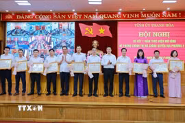 Phó Bí thư Thường trực Tỉnh ủy Nguyễn Hồng Phong và Phó Bí thư Tỉnh ủy Trịnh Tuấn Sinh trao Bằng khen của Chủ tịch Ủy ban Nhân dân tỉnh và tặng hoa cho các cá nhân có thành tích xuất sắc trong thực hiện mô hình hệ thống chính trị và chính quyền địa phương 2 cấp. (Ảnh TTXVN phát)