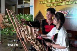 Sinh viên Việt Nam ở nước ngoài trải nghiệm nhạc cụ đàn T'rưng. (Ảnh: Tường Quân/TTXVN)