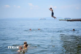 Người dân tắm biển tránh nóng tại Vladivostok, Nga. (Ảnh: THX/TTXVN)