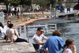 Người dân tránh nóng bên bờ sông Seine tại Paris, Pháp. (Ảnh: THX/TTXVN)