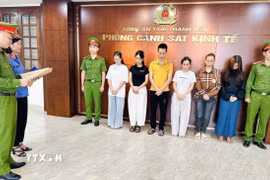 Cơ quan Cảnh sát điều tra Công an tỉnh Thanh Hóa thi hành Quyết định khởi tố vụ án, khởi tố bị can đường dây buôn bán nước hoa giả quy mô lớn. (Ảnh: TTXVN phát)