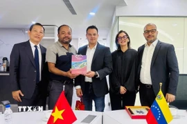 Trưởng Cơ quan thường trú TTXVN tại Mexico Trương Phi Hùng tặng quà lưu niệm cho Thứ trưởng Bộ Thông tin Truyền thông Venezuela Simón Arrechide. (Ảnh: AVN/TTXVN phát) 