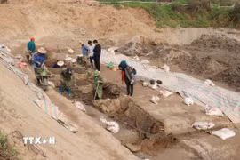 Một thuyền (đậy bạt) và thuyền bên cạnh được cố định với nhau bằng thanh gỗ, các nhà khảo cổ học cho rằng thuyền có kết cấu độc đáo, lần đầu tiên được phát hiện. (Ảnh: Thái Hùng/TTXVN)