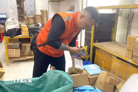 Nhân viên chuyển phát nhanh lấy hàng tại kho trên địa bàn Thành phố Hồ Chí Minh. (Ảnh: Hương Giang/TTXVN) 