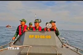 Cán bộ, chiến sỹ kêu gọi tàu thuyền vào nơi tránh trú bão số 9. (Ảnh: TTXVN phát) 