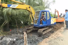 Đơn vị thi công triển khai xe cơ giới thi công hạng mục Cầu 9.000. (Ảnh: Tuấn Kiệt/TTXVN)