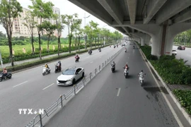 Xây dựng và triển khai phương án phân làn bằng dải phân cách cứng trên đường Phạm Văn Đồng. (Ảnh: Nguyễn Thắng/TTXVN)