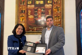 Nghị sỹ Victor Aldaya trao Đại sứ Ngô Minh Nguyệt bộ tem do Bưu chính Uruguay tháng 12/2013, nhân kỷ niệm 20 năm quan hệ ngoại giao Việt Nam-Uruguay, với chân dung của Đại tướng Võ Nguyên Giáp. (Ảnh: Diệu Hương/TTXVN) 