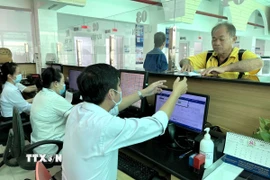 Cán bộ nhân viên Tây Ninh tận tình hỗ trợ người dân. (Ảnh: Đức Hạnh/TTXVN) 