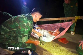 Quân y Đồn Biên phòng Hòn Chuối khám, sơ cứu ban đầu cho bệnh nhân Nguyễn Phát Đạt. (Ảnh: TTXVN phát)
