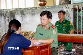 Công an Tây Ninh làm việc với các công dân từ Campuchia về nước. (Ảnh: TTXVN phát) 