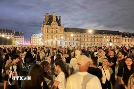 Hàng chục nghìn người tới tập trung tại vườn hoa Tuileries và bảo tàng Louvre để chứng kiến Ngọn lửa Olympic. (Ảnh: Ngọc Hiệp/TTXVN)