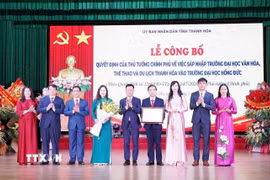 Thứ trưởng Bộ GD & ĐT Lê Quân trao Quyết định của Thủ tướng Chính phủ về sáp nhập Trường Đại học Văn hóa, Thể thao và Du lịch Thanh Hóa vào Trường Đại học Hồng Đức. (Ảnh Khiếu Tư/TTXVN)