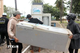 Chuyển đồ điện đã được sữa chữa về tận nhà cho người dân. (Ảnh: Nguyễn Thanh/TTXVN)