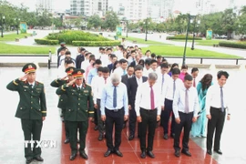 Đại sứ Việt Nam tại Vương quốc Campuchia Nguyễn Minh Vũ chỉnh trang vòng hoa tưởng niệm các anh hùng liệt sỹ tại Tượng đài Hữu nghị Campuchia-Việt Nam ở thủ đô Phnom Penh. (Ảnh: Hoàng Minh/TTXVN)