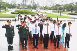 Đại sứ Việt Nam tại Vương quốc Campuchia Nguyễn Minh Vũ chỉnh trang vòng hoa tưởng niệm các anh hùng liệt sỹ tại Tượng đài Hữu nghị Campuchia-Việt Nam ở thủ đô Phnom Penh. (Ảnh: Hoàng Minh/TTXVN)