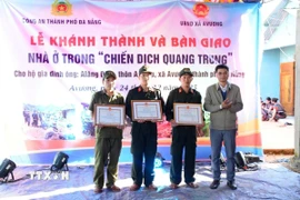 Chủ tịch Ủy ban Nhân dân xã A Vương Briu Quân tặng Giấy khen cho lực lượng tham gia “Chiến dịch Quang Trung” xây, sửa nhà ở cho đồng bào bị thiệt hại do thiên tai vào cuối tháng 10 và đầu tháng 11/2025. (Ảnh: TTXVN phát)