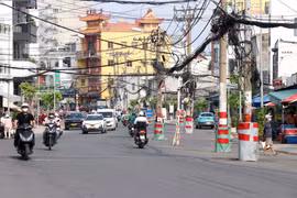 Nhiều trụ điện trên tuyến vẫn chưa được di dời, khiến dự án mở rộng đường Chu Văn An chưa thể hoàn thành, đồng thời ảnh hưởng đến an toàn giao thông và mỹ quan đô thị. (Ảnh: Tiến Lực/TTXVN)