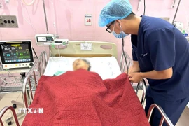 Bác sỹ thăm khám trường hợp bệnh bị ngộ độc thực phẩm nặng tại khoa Hồi sức tích cực. (Ảnh: TTXVN phát)
