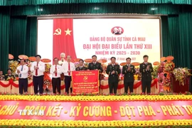 Tỉnh ủy Cà Mau tặng Đại hội bức trướng mang dòng chữ ‘‘Trung thành-Dũng cảm-Đoàn kết-Quyết thắng’’. (Ảnh: Kim Há/TTXVN)