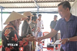 Phó Chủ tịch Uỷ ban Mặt trận Tổ quốc Việt Nam tỉnh Cà Mau Nguyễn Văn Khởi thăm hỏi, động viên và trao hỗ trợ cho 9 hộ dân bị thiệt hại trong vụ cháy. (Ảnh: TTXVN phát)