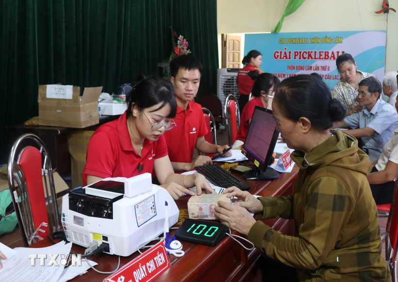 Người dân xã Gia Bình, tỉnh Bắc Ninh nhận tiền hỗ trợ chi trả bồi thường giải phóng mặt bằng. (Ảnh: Thanh Thương/TTXVN)