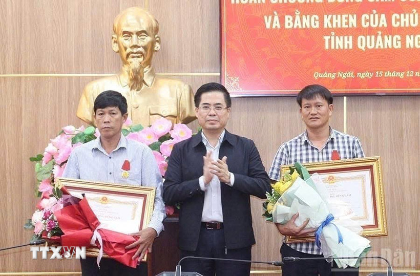 Chủ tịch Ủy ban Nhân dân tỉnh Quảng Ngãi Nguyễn Hoàng Giang trao Huân chương Dũng cảm của Chủ tịch nước cho 2 công dân Lý Sơn. (Ảnh: TTXVN phát)