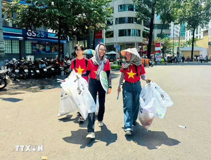 Các tình nguyện viên nhóm Xanh Việt Nam tham gia dọn vệ sinh đường phố sau buổi tổng duyệt diễu binh. (Ảnh: TTXVN phát)