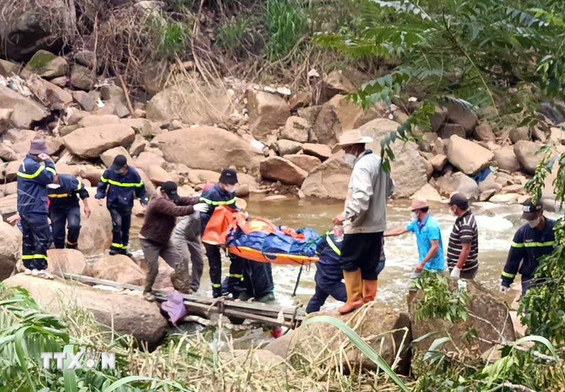 Lực lượng chức năng băng rừng đưa thi thể nạn nhân về nơi cư trú. (Ảnh: TTXVN phát)