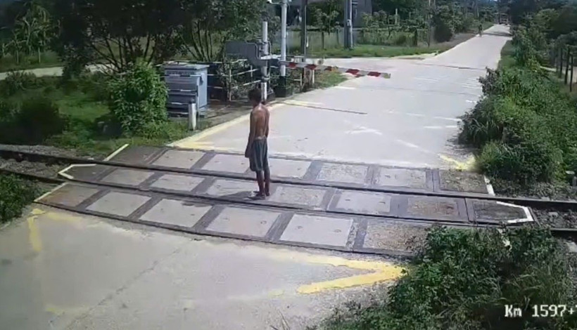 Người đàn ông đứng im trên đường ray. (Hình ảnh cắt từ clip) Người đàn ông đứng im trên đường ray. (Hình ảnh cắt từ clip)