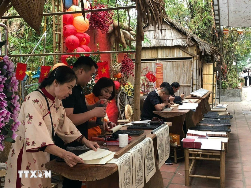 Nghệ nhân làng nghề khắc, in mộc bản Thanh Liễu tham gia nhiều sự kiện văn hóa để giới thiệu, quảng bá những giá trị về làng nghề tới công chúng. (Ảnh: Mạnh Minh/TTXVN)