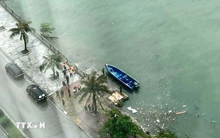 Chuyển thi thể vừa tìm được trong vụ lật tàu tại Hạ Long lên bờ để xác minh danh tính. (Ảnh: TTXVN phát)