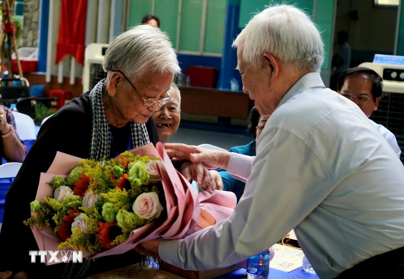 Nguyên Chủ tịch nước Nguyễn Minh Triết tặng hoa cho đại biểu. (Ảnh Hương Giang/TTXVN)