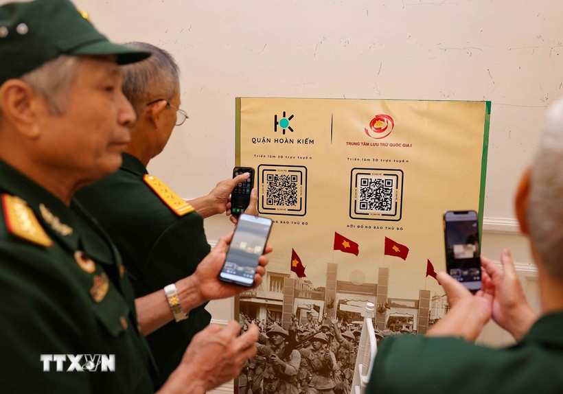 Các cựu chiến binh quét mã QR để xem triển lãm 3D trực tuyến “Hỡi đồng bào Thủ đô”. (Ảnh: Thanh Tùng/TTXVN)