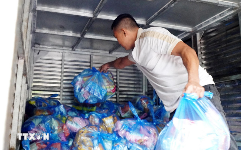 Xếp hàng cứu trợ lên xe tải để chở vào cứu trợ người dân vùng lũ Gia Lai. (Ảnh: Lê Phước Ngọc/TTXVN)