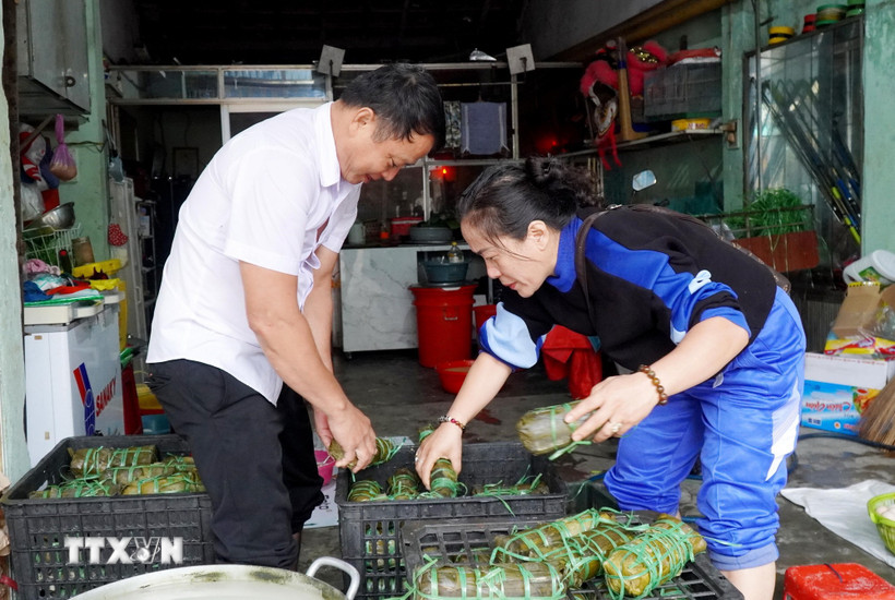 Nhóm thiện nguyện xếp bánh tét vào khay chứa để chuyển đến người dân vùng lũ Gia Lai. (Ảnh: Lê Phước Ngọc/TTXVN)