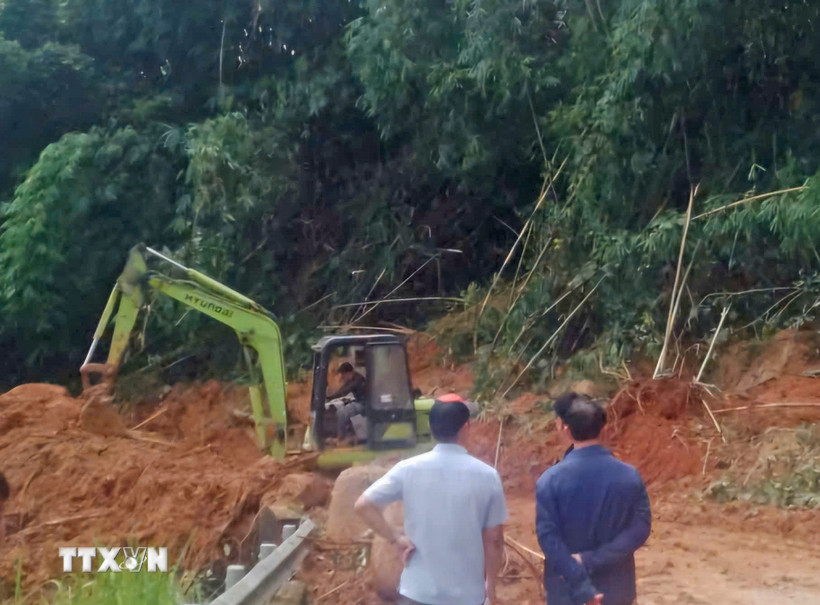 Lực lượng chức năng nỗ lực giải phóng hiện trường các điểm sạt lở để thông tuyến quốc lộ 28, đoạn qua đèo Gia Bắc (xã Sơn Điền, Lâm Đồng). (Ảnh: TTXVN phát)