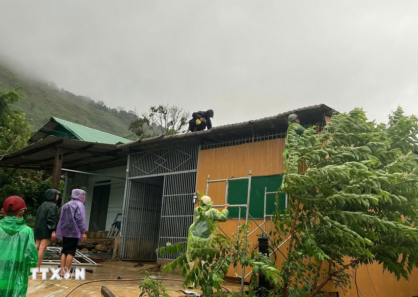 Lực lượng chức năng tỉnh Kon Tum hỗ trợ người dân khắc phục thiệt hại về nhà ở. (Ảnh: TTXVN phát)