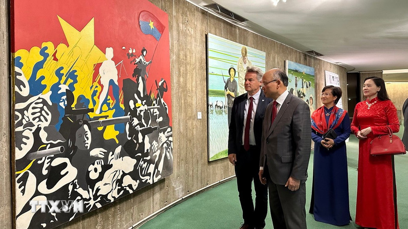 Bí thư toàn quốc PCF Fabien Roussel giới thiệu với Đại sứ Việt Nam tại Pháp Đinh Toàn Thắng một bức tranh cổ động được các họa sĩ Pháp thể hiện vào những năm 1960. (Ảnh: Nguyễn Thu Hà/TTXVN)