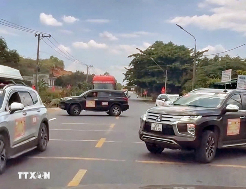 2 chiếc xe ngang nhiên đậu so le trên cả 2 chiều, chặn đường để đoàn xe doanh nhân băng qua Quốc lộ 20. (Ảnh: TTXVN phát)