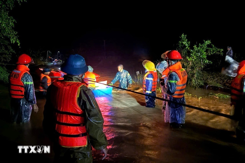 Lực lượng chức năng xã Yang Mao di dời các hộ dân vùng ngập lụt đên nơi an toàn trong đêm. (Ảnh: TTXVN phát)