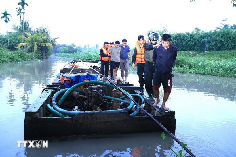 Lực lượng Công an Đồng Nai khống chế, bắt giữ các đối tượng khai thác cát trái phép. (Ảnh: TTXVN phát)