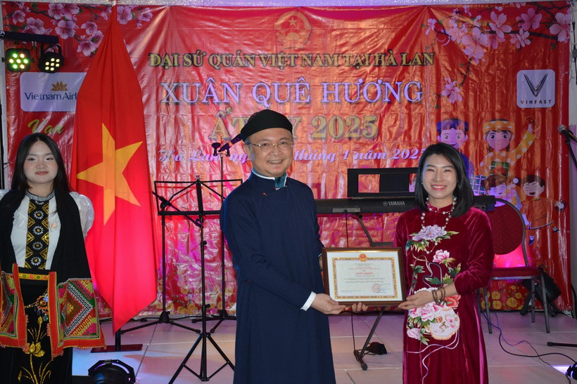 Đại sứ Ngô Hướng Nam trao bằng khen cho đại diện công ty VinFast Hà Lan vì những đóng góp tích cực trong công tác hỗ trợ cộng đồng. (Ảnh: TTXVN phát)