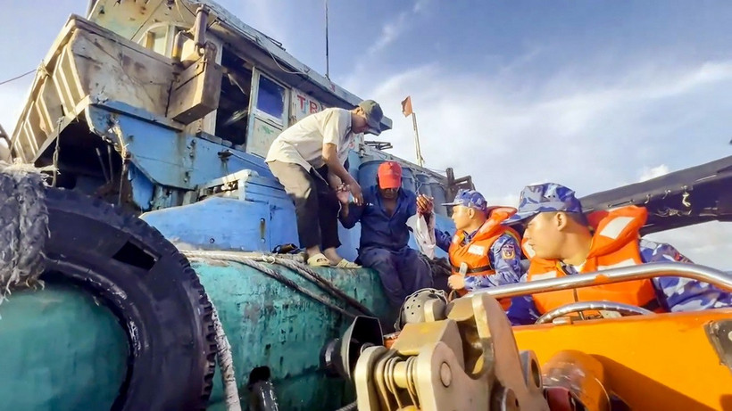 Lực lượng cảnh sát biển tiếp cận tàu cá, đón ngư dân lên tàu cấp cứu. (Ảnh minh họa: TTXVN phát)