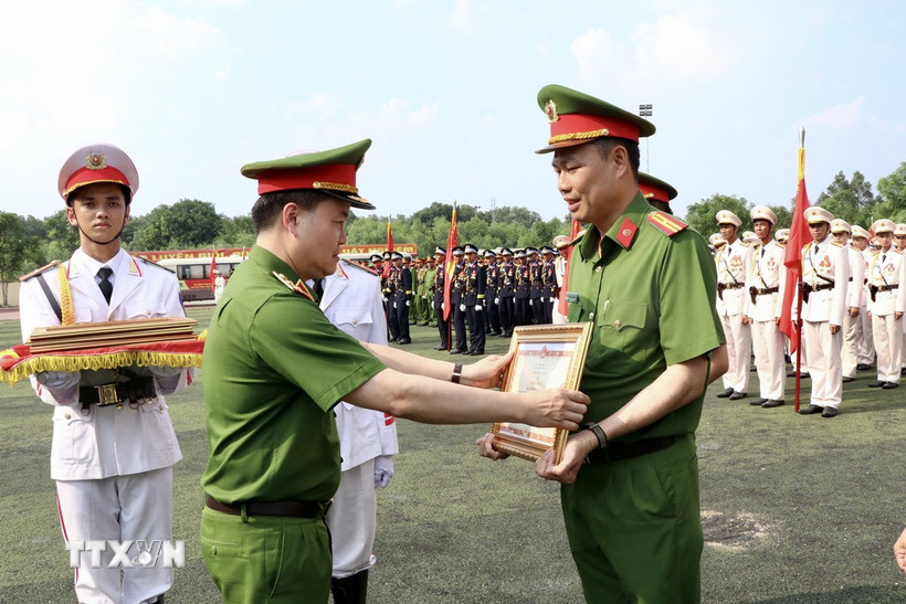 Trung tướng Nguyễn Ngọc Vân, Tư lệnh Cảnh sát cơ động, phó Trưởng Tiểu ban Thường trực tổ chức diễu binh, diễu hành (Bộ Công an) tặng Bằng khen của Bộ Công an cho các học viên có thành tích xuất sắc tham gia diễu binh, diễu hành trong Lễ kỷ niệm. (Ảnh: Lê Xuân/TTXVN)