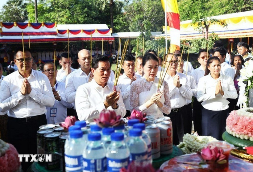 Đô trưởng Phnom Penh Khuong Sreng (bên trái, hàng đầu) cùng các đại biểu thực hiện nghi thức dâng hương tưởng niệm các nạn nhân dưới chế độ Khmer Đỏ diệt chủng. (Ảnh: AKP/TTXVN phát)