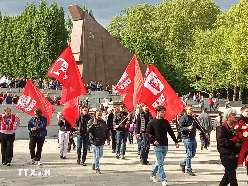 Đoàn Ban chấp hành đảng Cộng sản Đức mang theo cờ tiến vào tượng đài Xô viết ở Công viên Treptow để kỷ niệm Ngày Chiến thắng phátxít. (Ảnh: Phương Hoa/TTXVN)