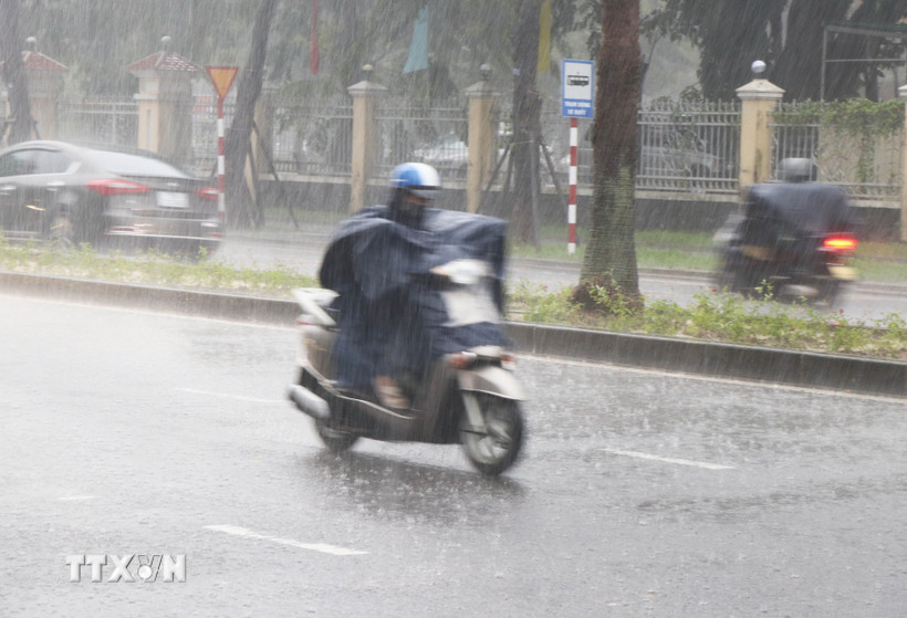 Người dân đi lại trong mưa lớn sáng 27/9 trên đường Đống Đa, phường Thuận Hóa, thành phố Huế. (Ảnh: Nguyên Lý/TTXVN)
