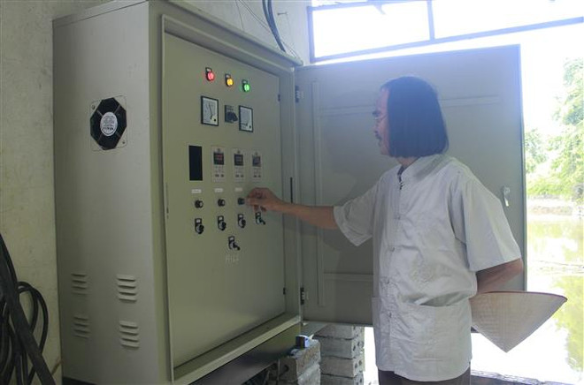 Ông Lê Đức Vinh kiểm tra máy móc tại Trạm cấp nước sạch sinh hoạt nông thôn xã Ninh Hải. (Ảnh: Hải Yến/TTXVN) Sáng ngời những tấm gương 'tàn nhưng không phế' của Ninh Bình ảnh 2